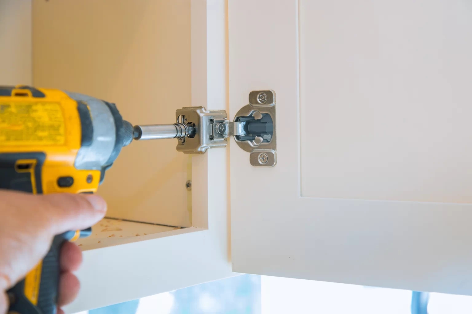 A hand holding a screwdriver