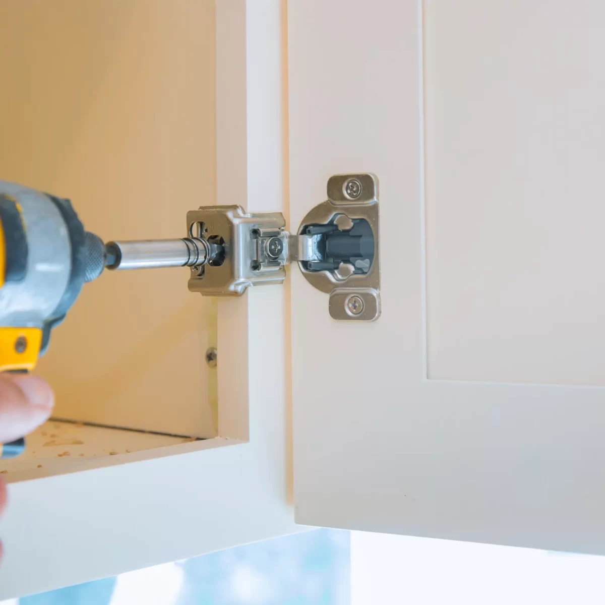 A hand holding a screwdriver